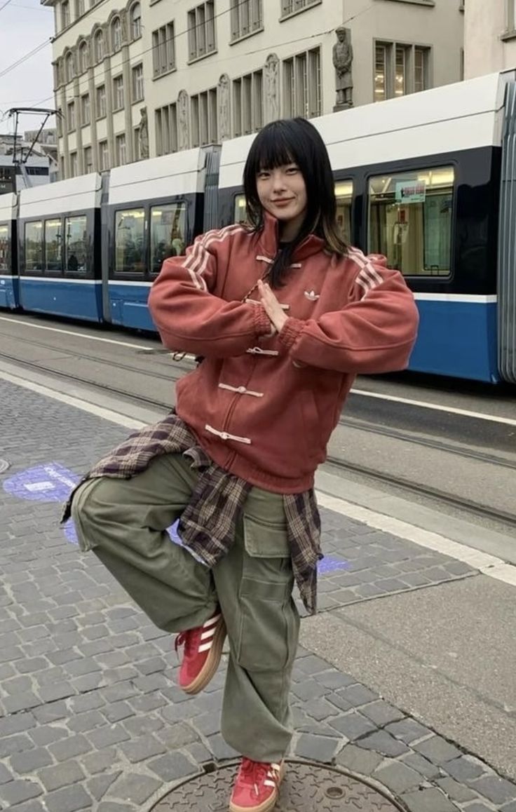 Person posing on a street with a tram in the background with cny jacket
